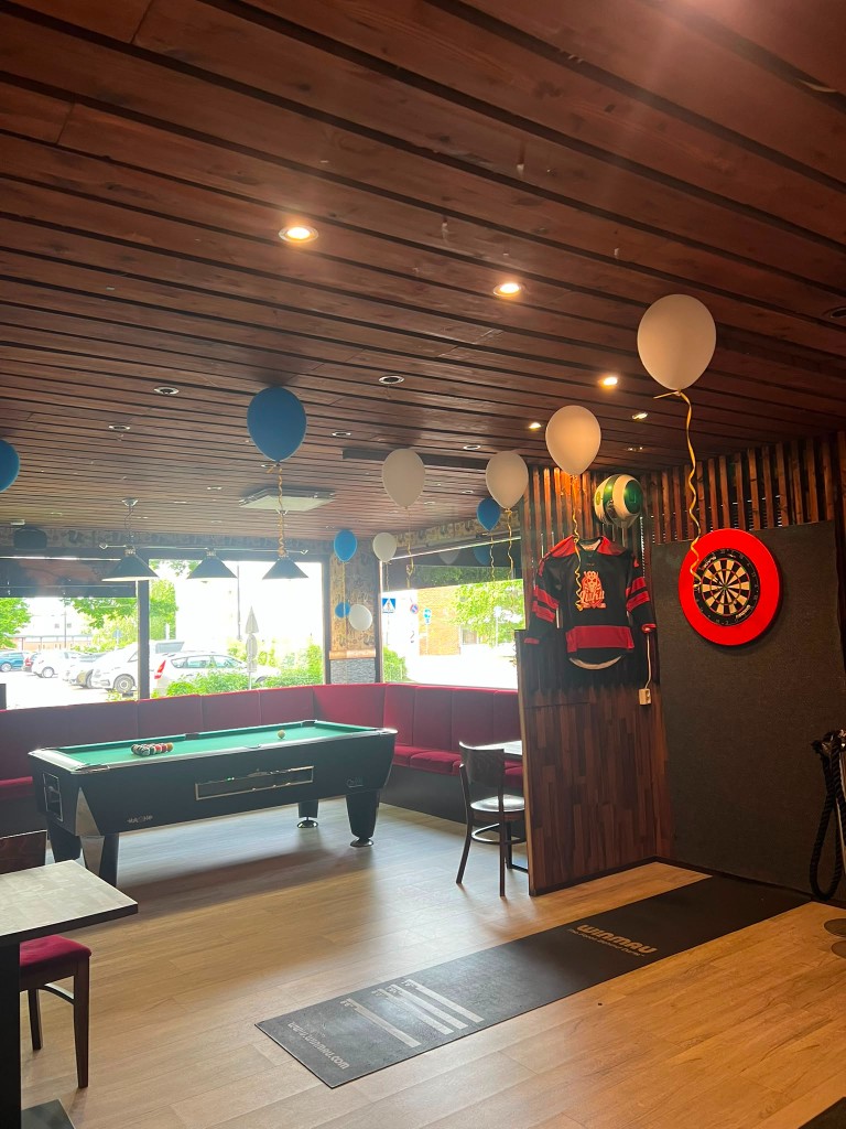 Biljardipöytä ja darts-seinä.