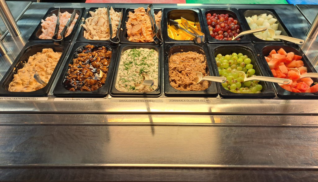 Runsas salaattibuffet lounaspöydässä.